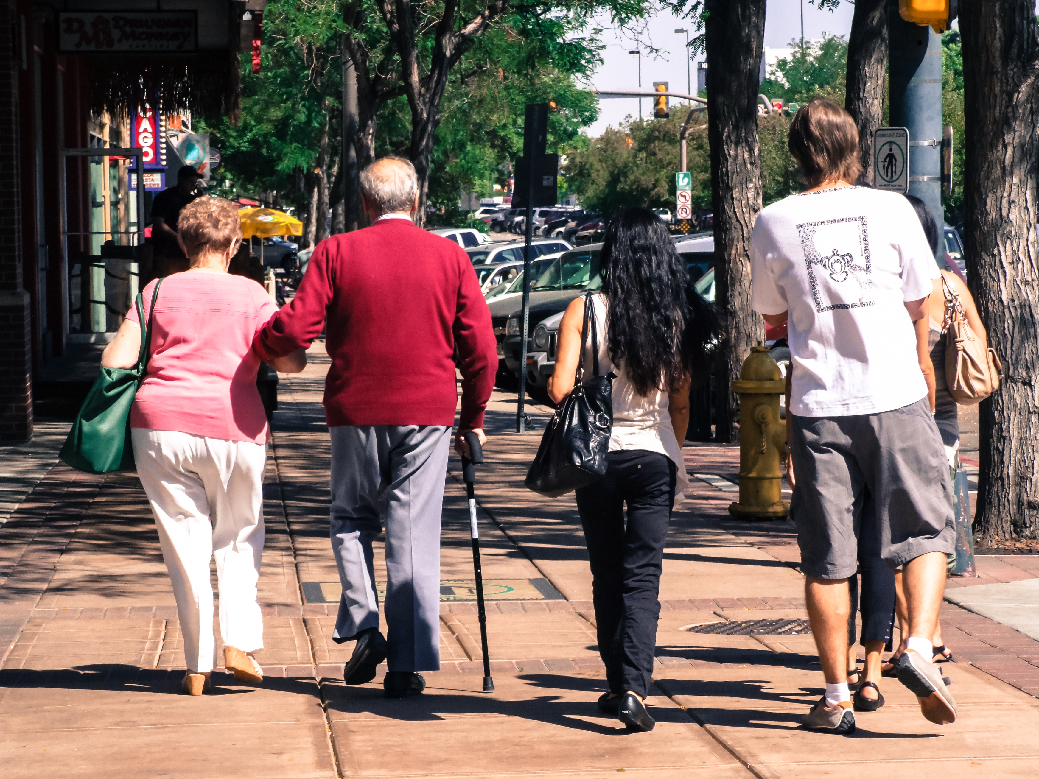 Personas mayores caminando en la calle junto a unos jóvenes