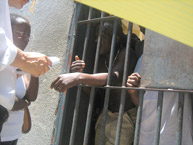 Miembros de la delegación de la Relatoría de Personas Privadas de Libertad de la CIDH toman testimonio a un interno en una penitenciaría de Puerto Príncipe, Haití