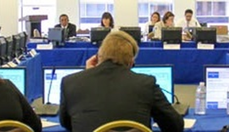 Group of people in a meeting looking at computer screens