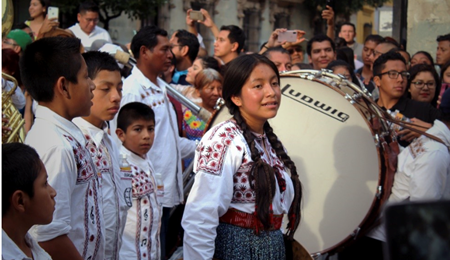 Personas indígenas tocando instrumentos musicales en una celebración  